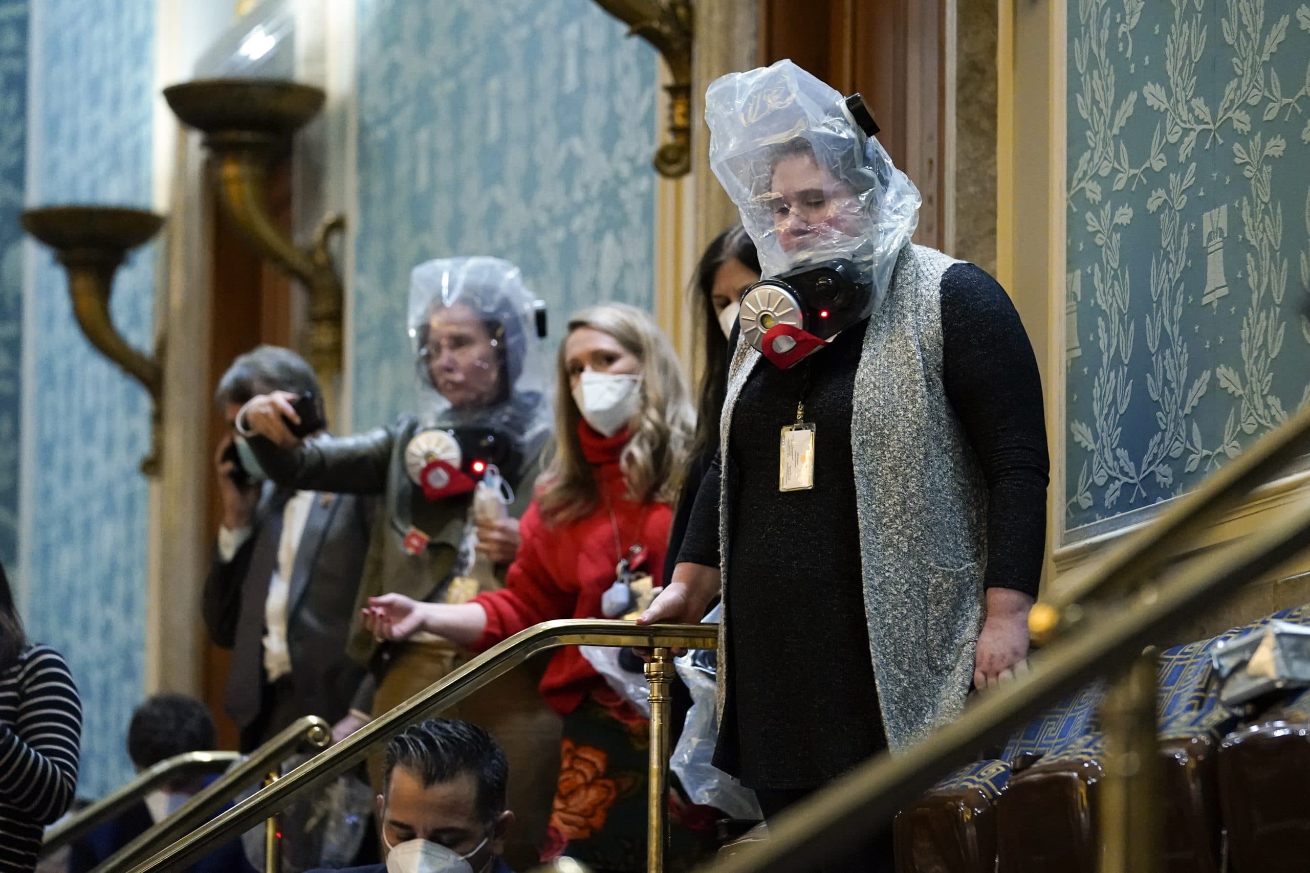 People are seen in the House gallery as protesters try to break into the House Chamber at the U.S. Capitol on Wednesday, Jan. 6, 2021, in Washington. (AP PHOTO/ANDREW HARNICK)