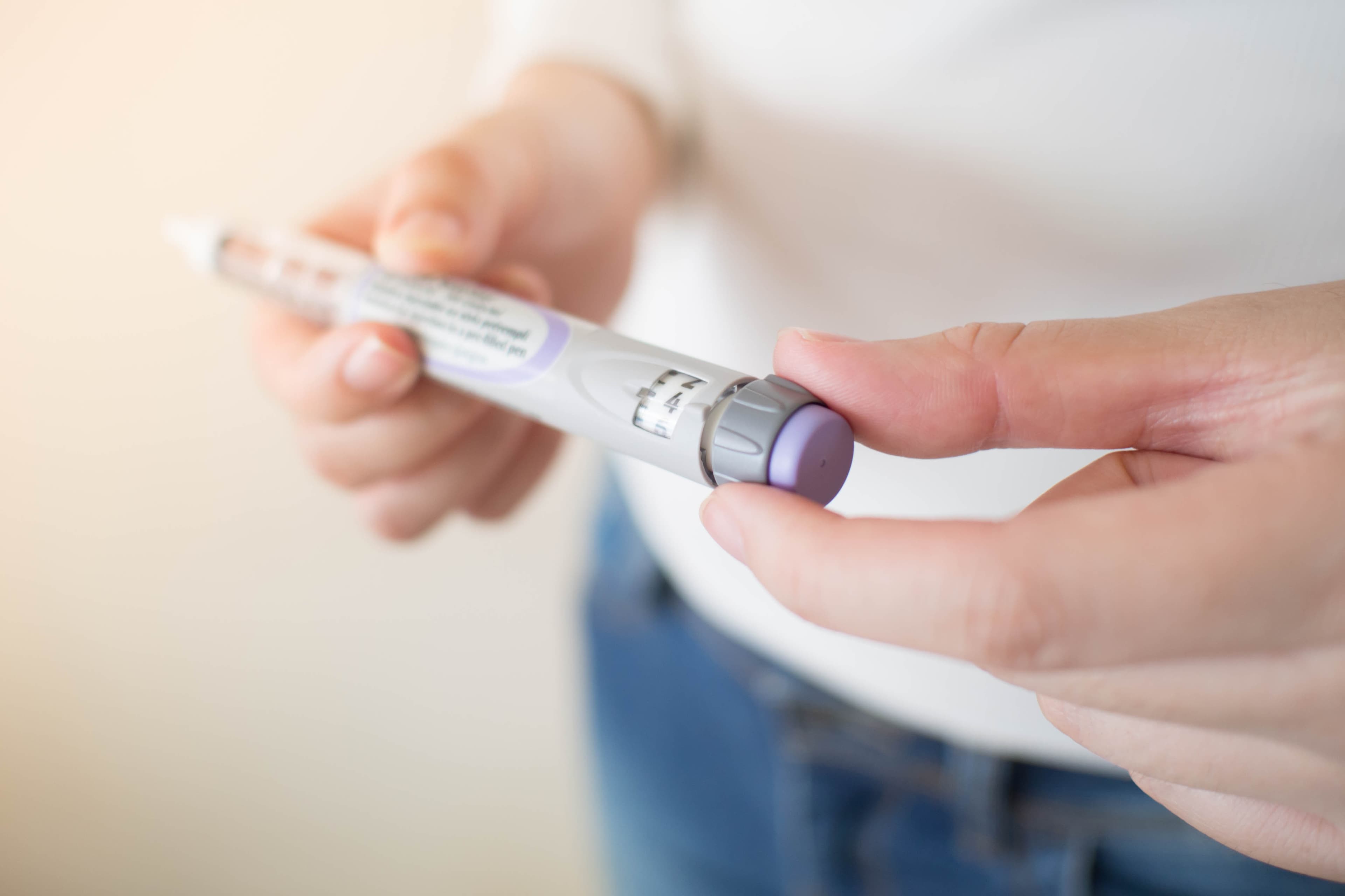 Diabetes patient turn knob on end of insulin pen and dial up cor