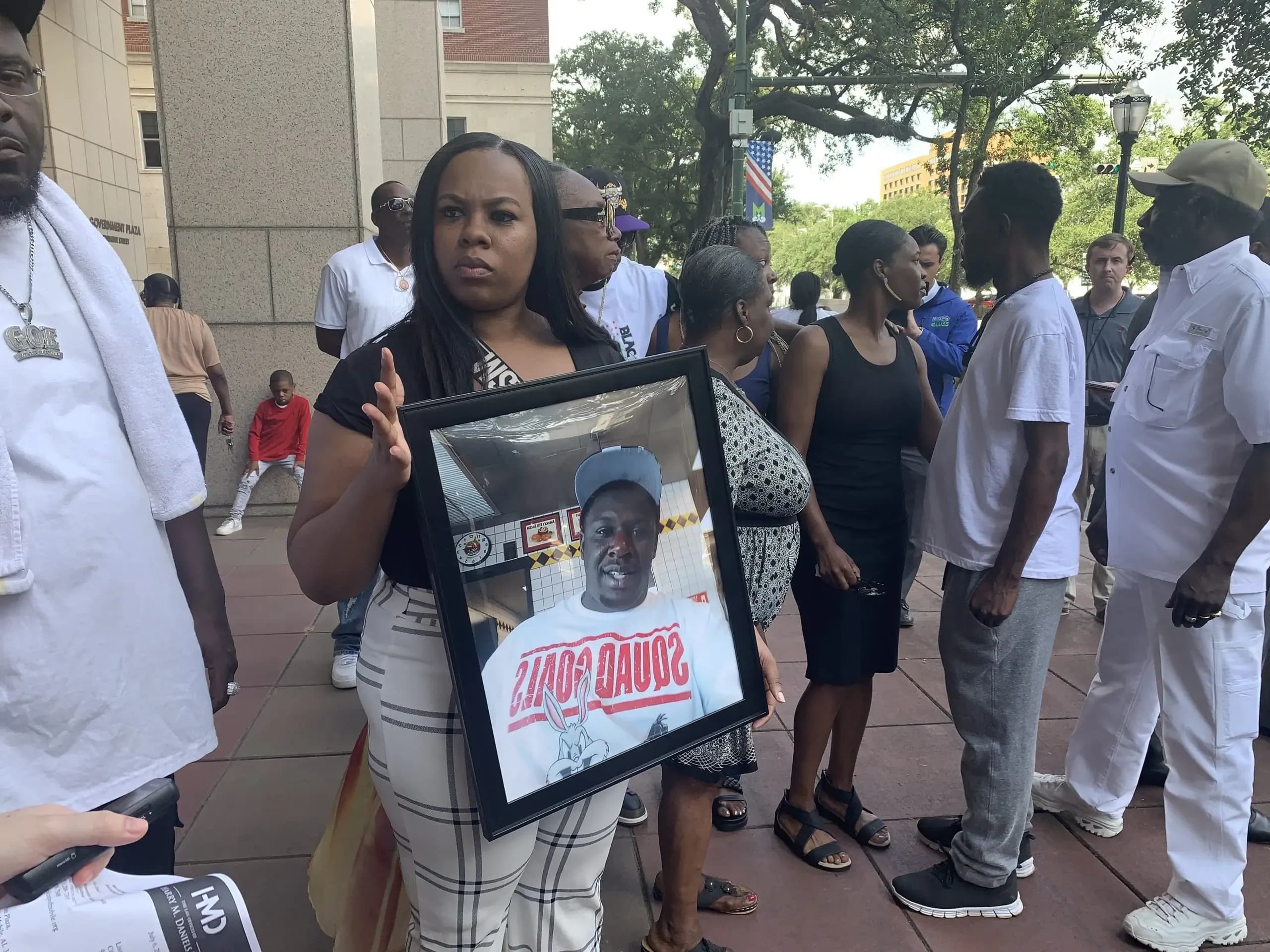 Jawan Dallas's sister, Maria Dallas, holds a picture of her late brother.