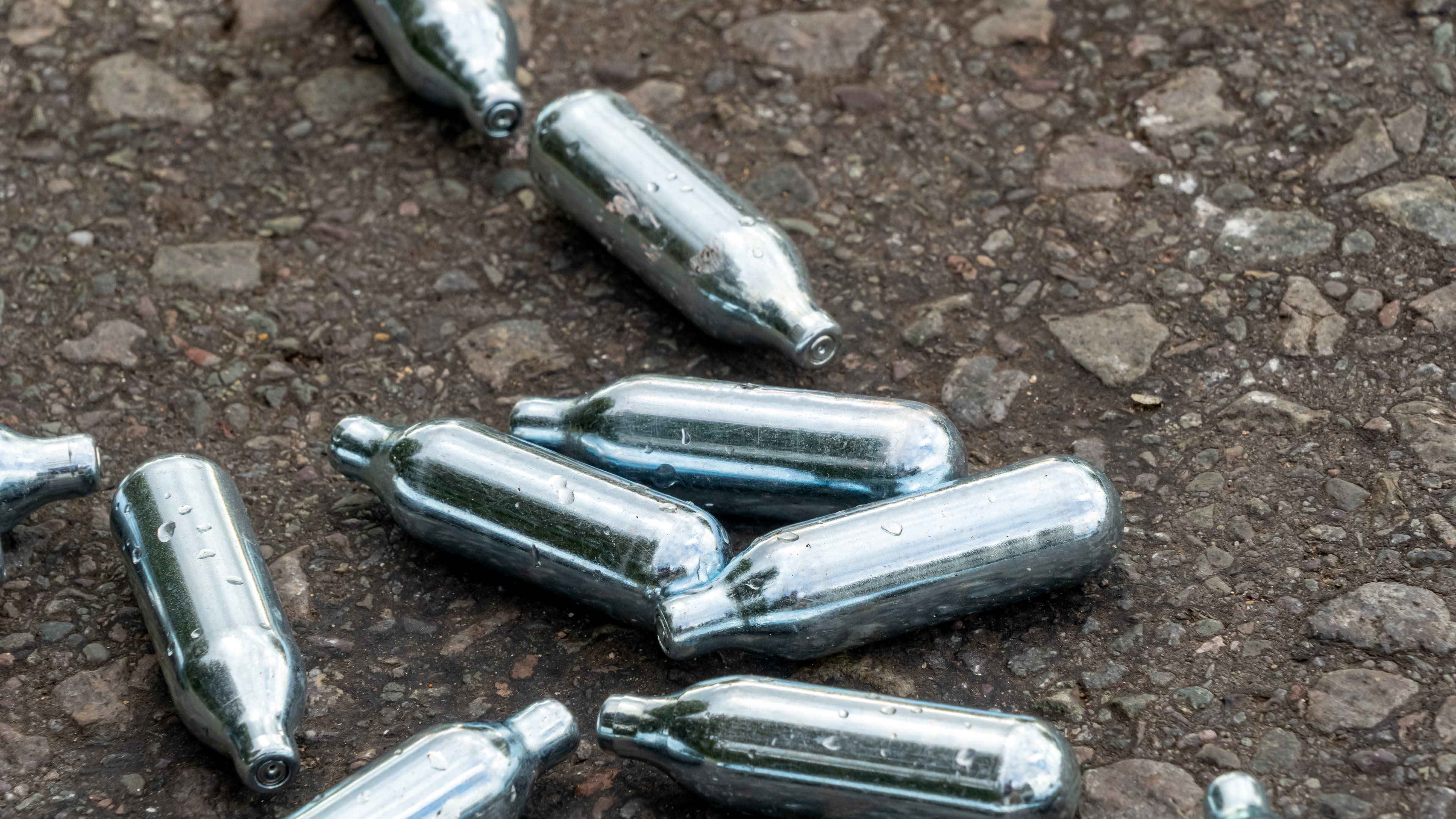 Nitrous Oxide used gas canisters discarded on the roadside.