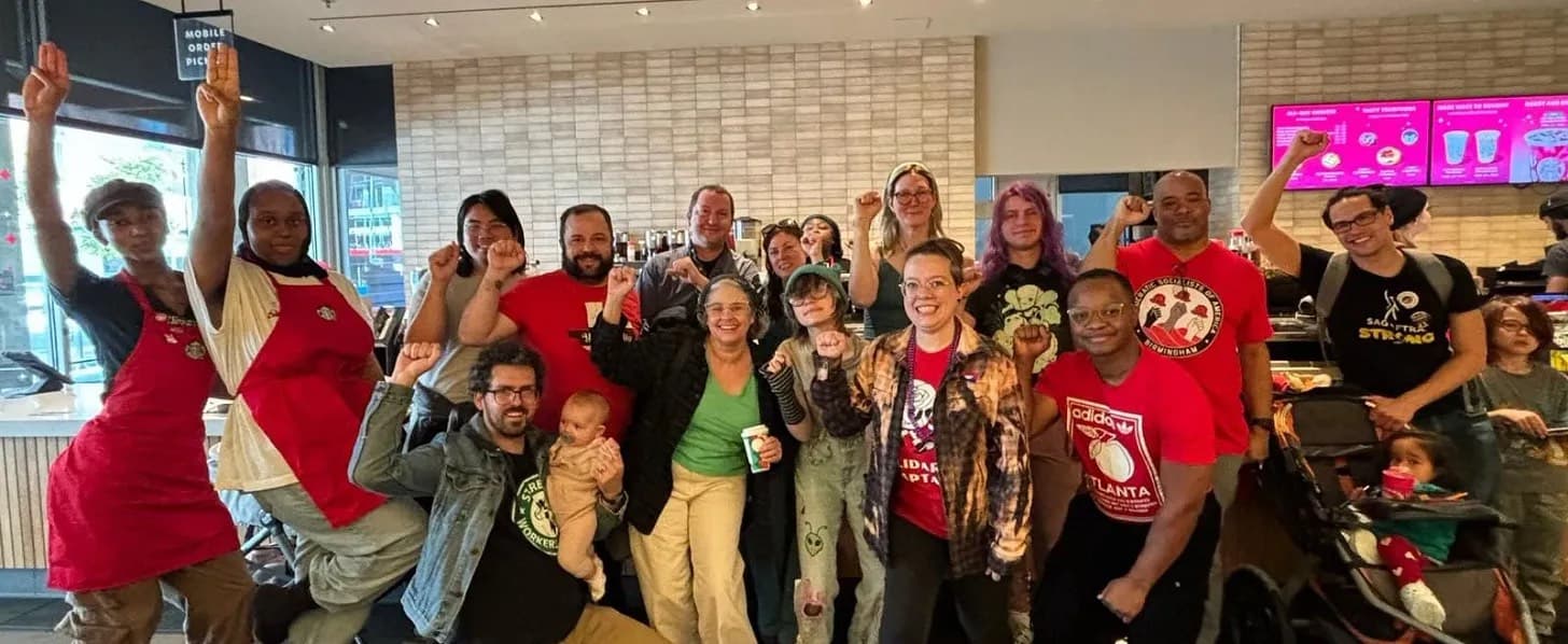 A photo of Starbucks workers and Birmingham DSA members with raised fists as a symbol of solidarity.