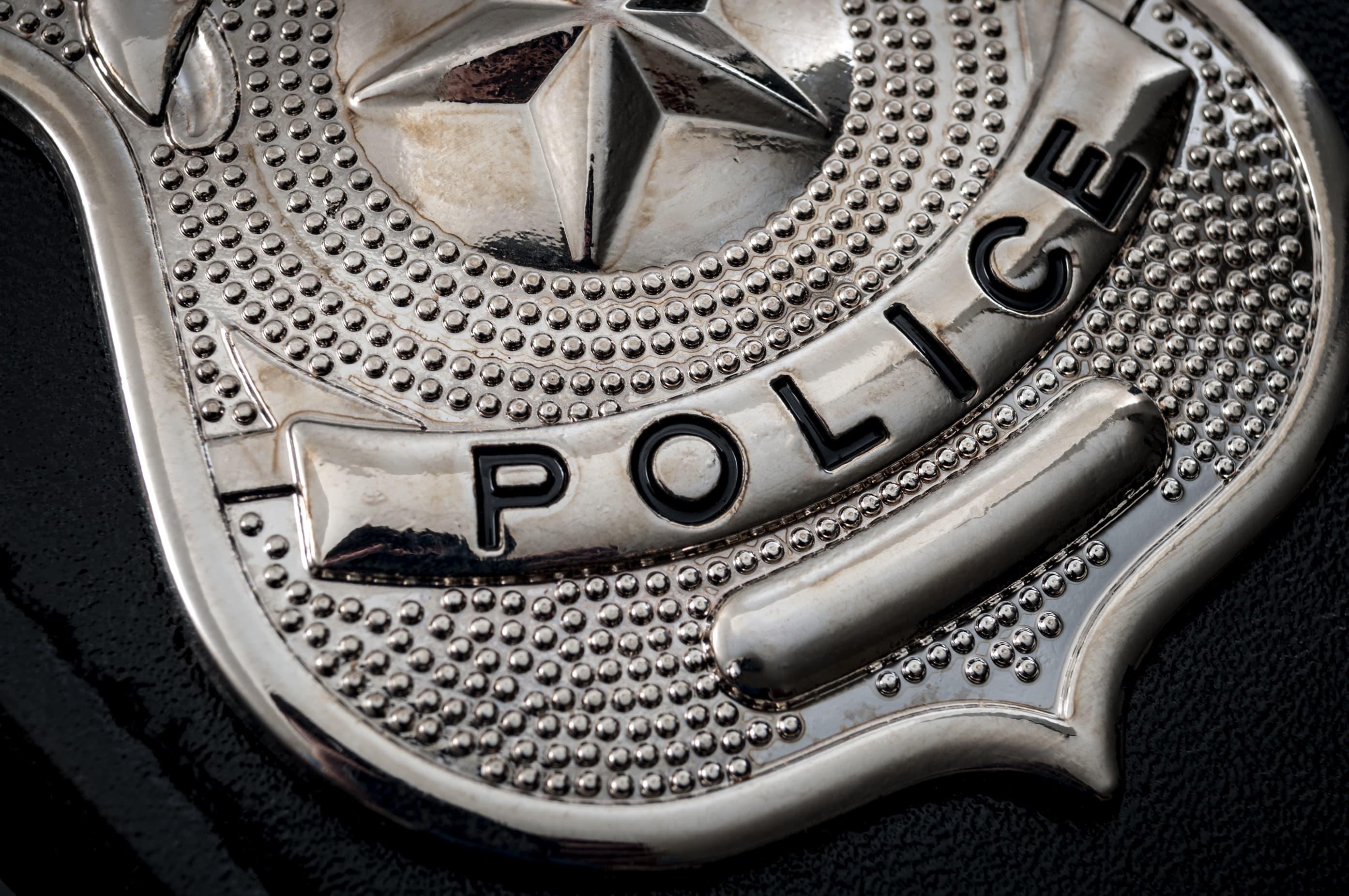 Cops and police officer badge with macro close up on the "police" text of a cop badge