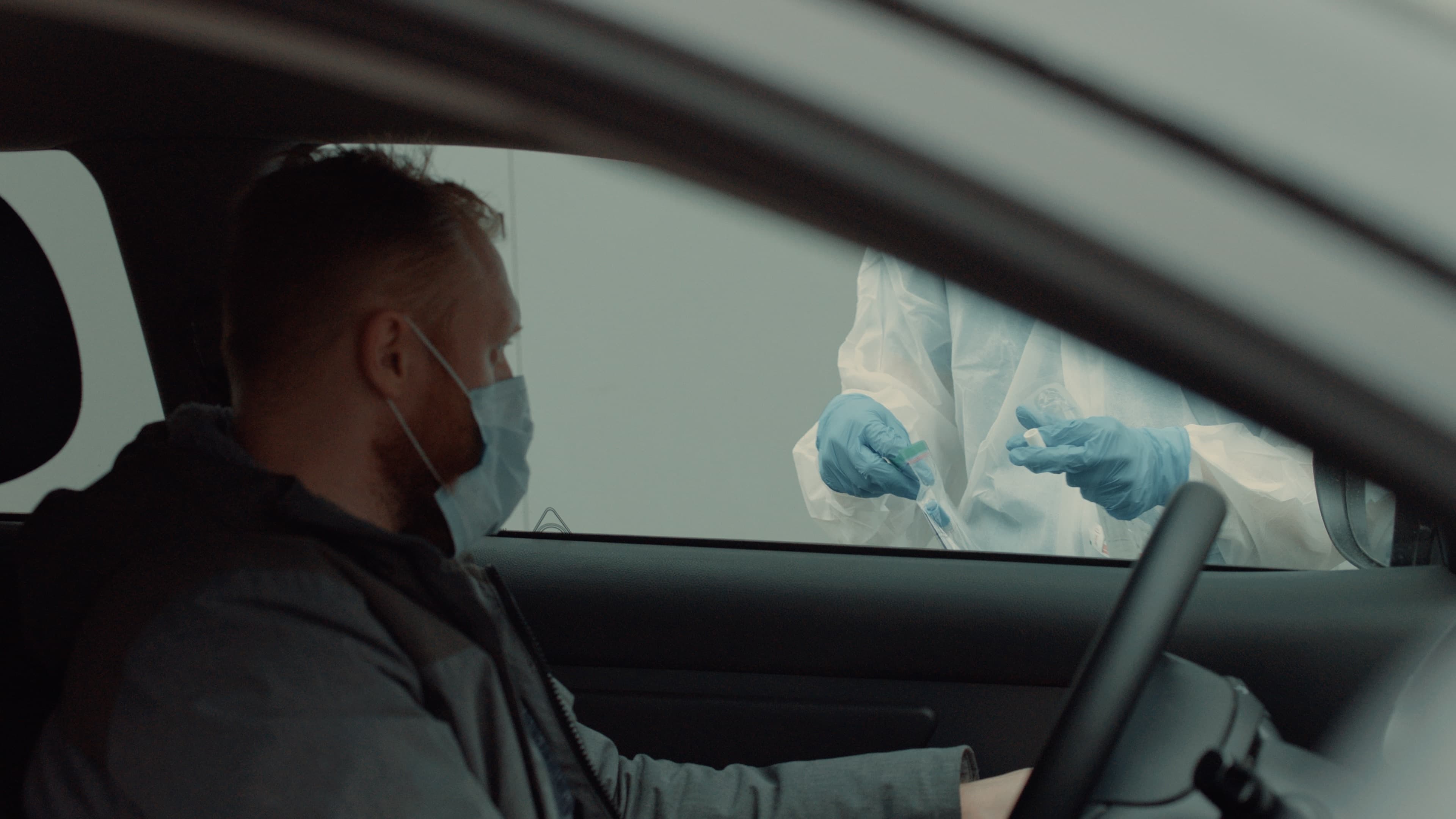Patient is being tested in his vehicle on a drive-through coronavirus COVID-19 testing location. Pandemic, infection