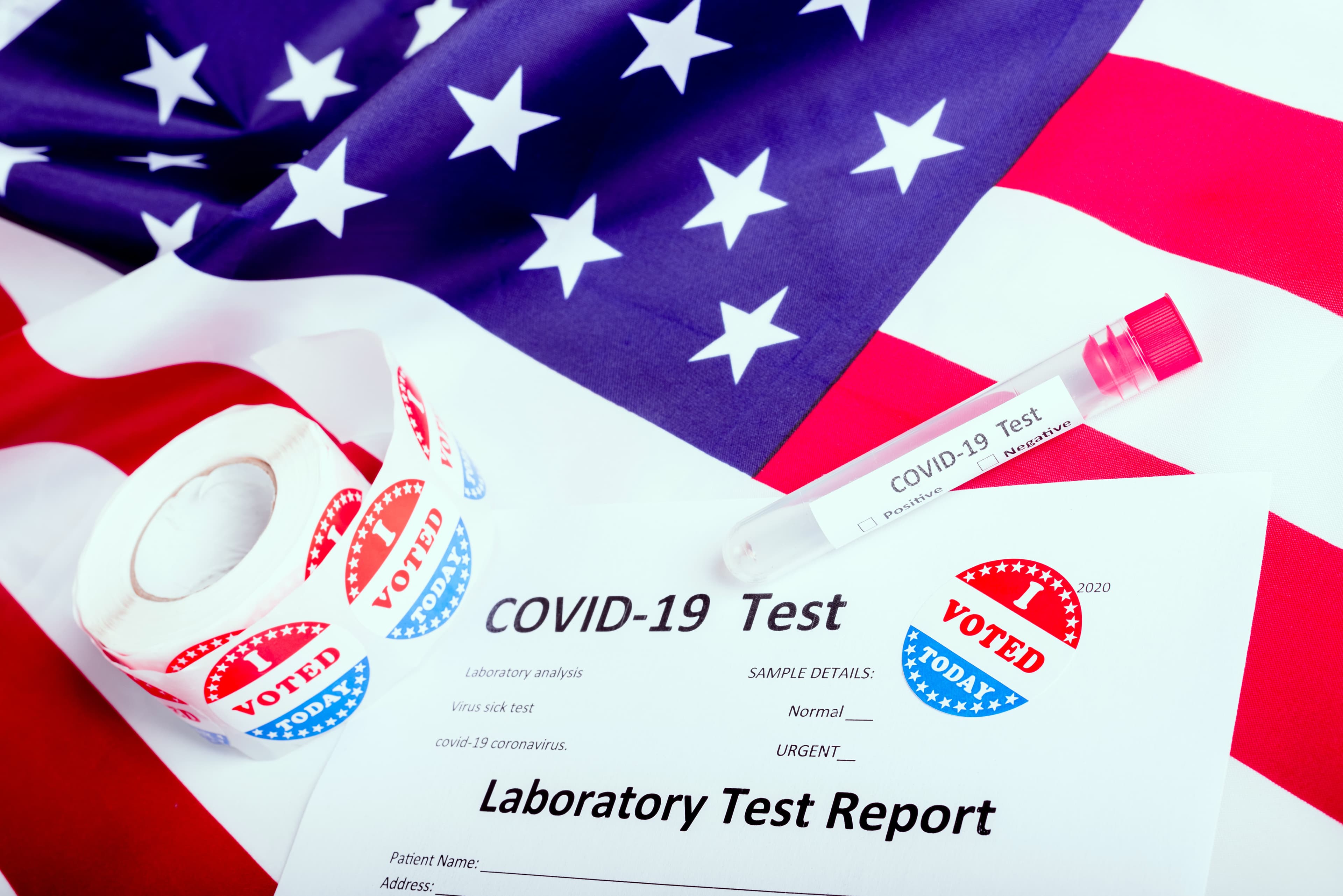 I voted sticker on the American flag and some test tubes of covid19 during the election time in the United States.