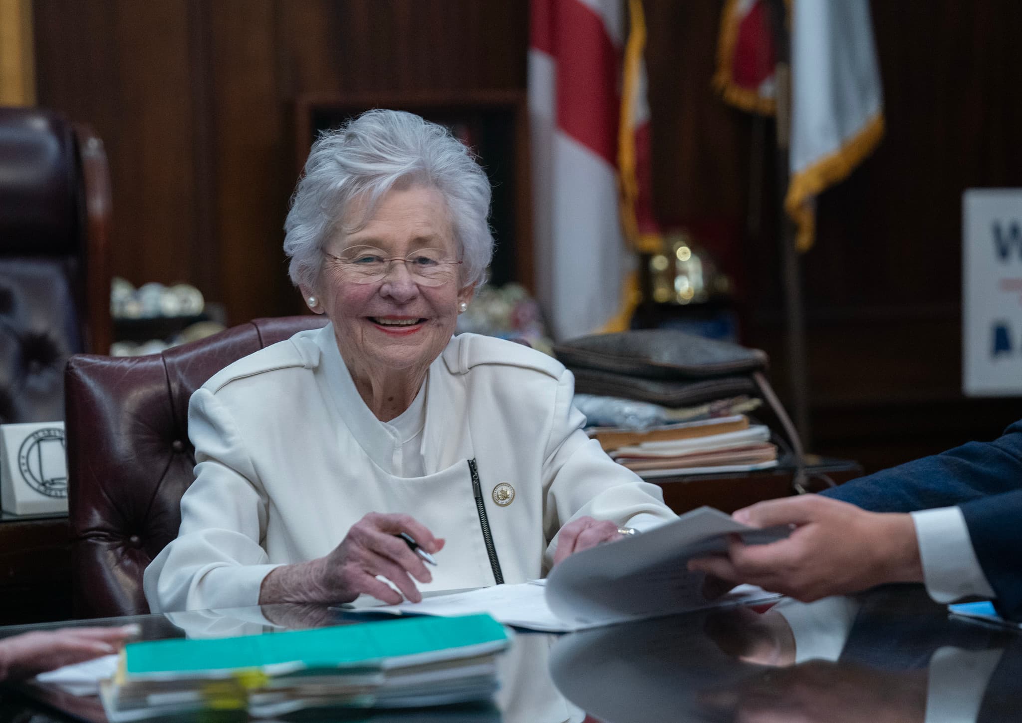 Governor Kay Ivey signs legislation during the last bill review meeting of her term.