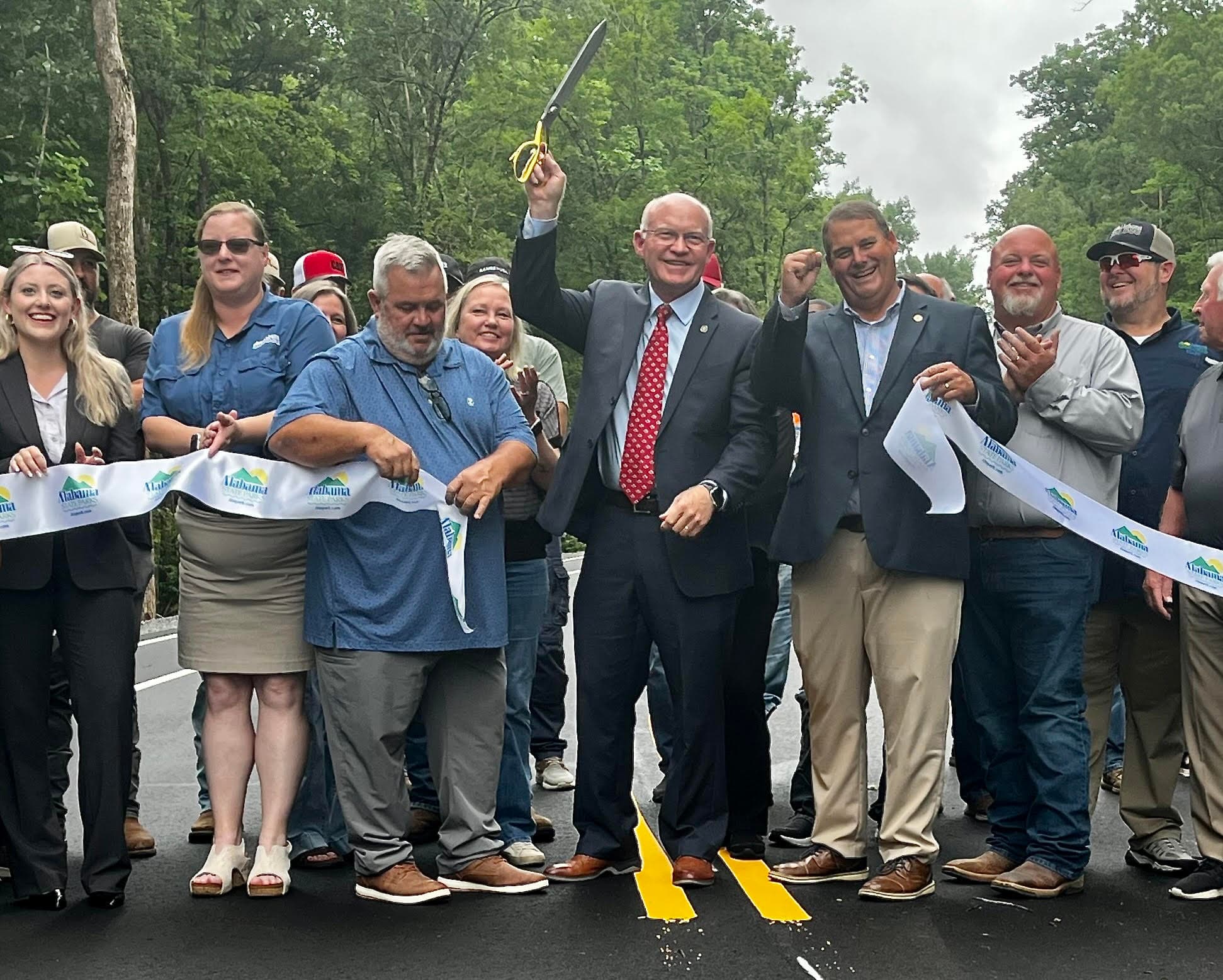 State Rep. David Standridge celebrates after cutting the ceremonial ribbon for the new access road at Rickwood Caverns State Park on Monday, June 8, 2026.