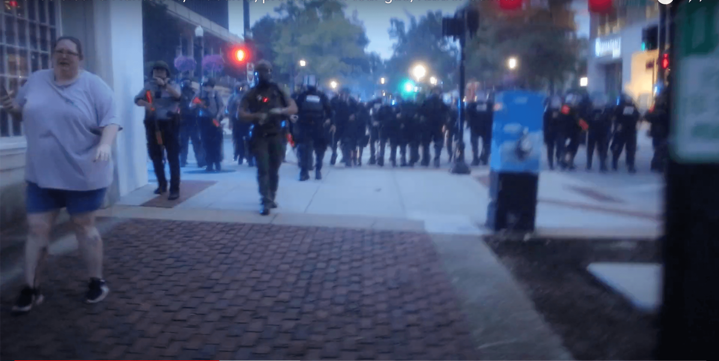 April Grubb walks ahead of police after she was shot six times with rubber bullets. Image courtesy of David Capo.