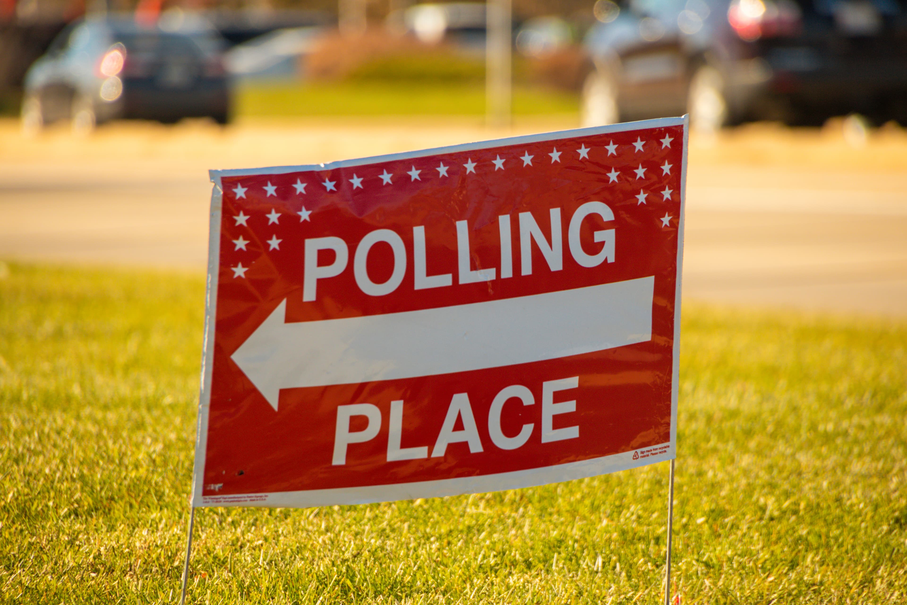Election polling place yard sign with white text and red backgro