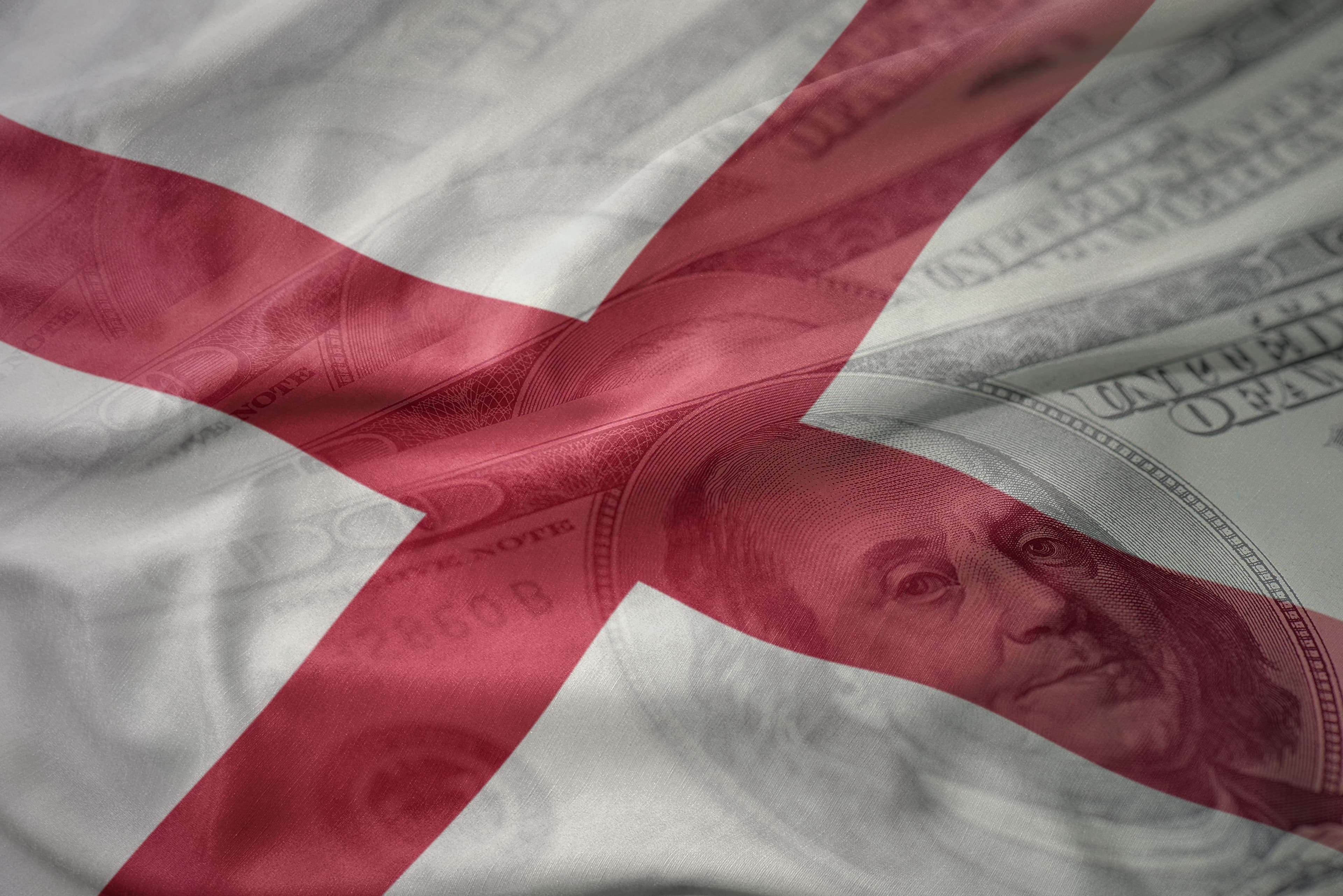 colorful waving flag of alabama state on a american dollar money background. finance concept