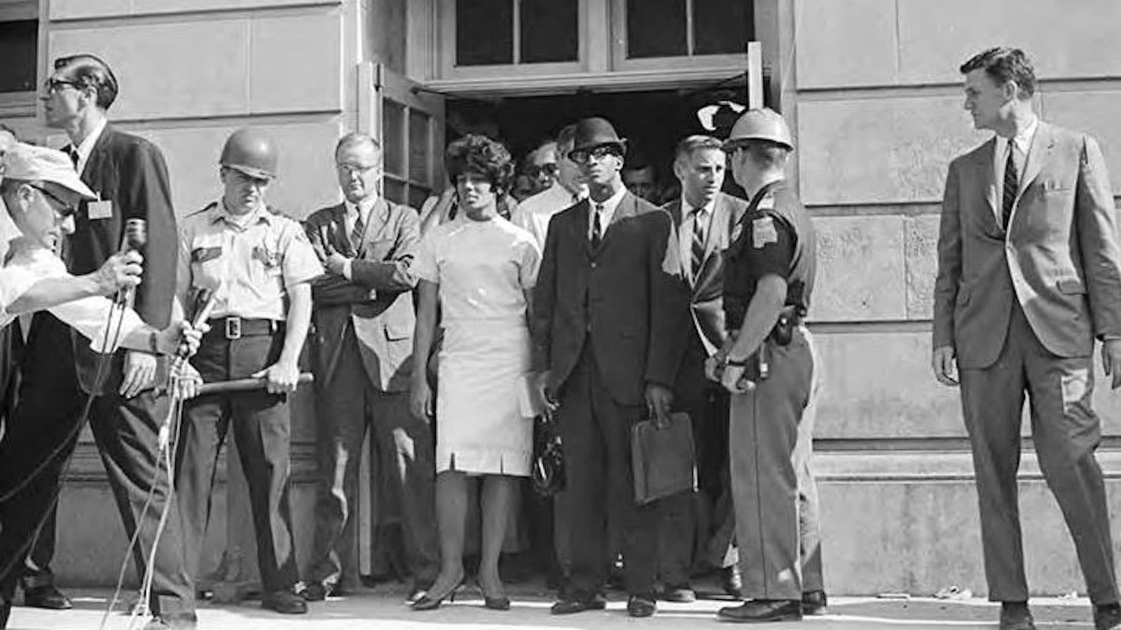 Vivian Malone, center in a white dress, and James Hood, on her left holding a briefcase, outside Foster Auditorium on June 11, 1963.