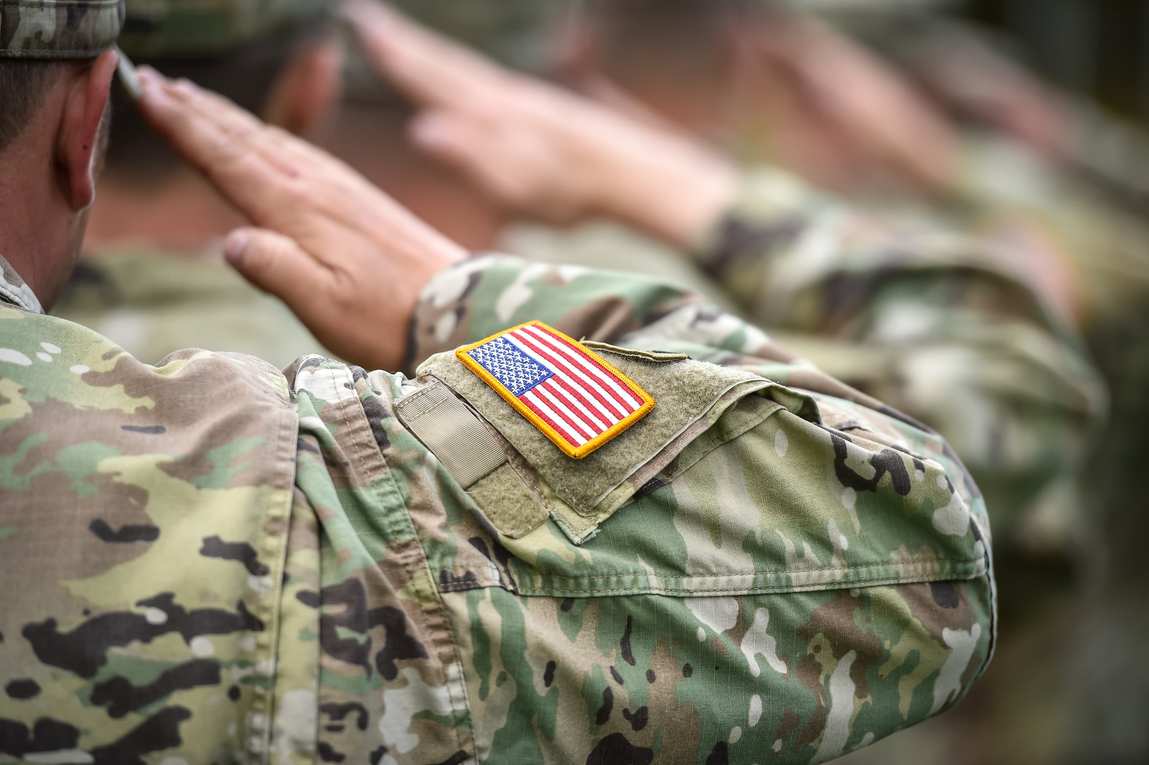 Detail shot with american flag on soldier uniform, giving the ho
