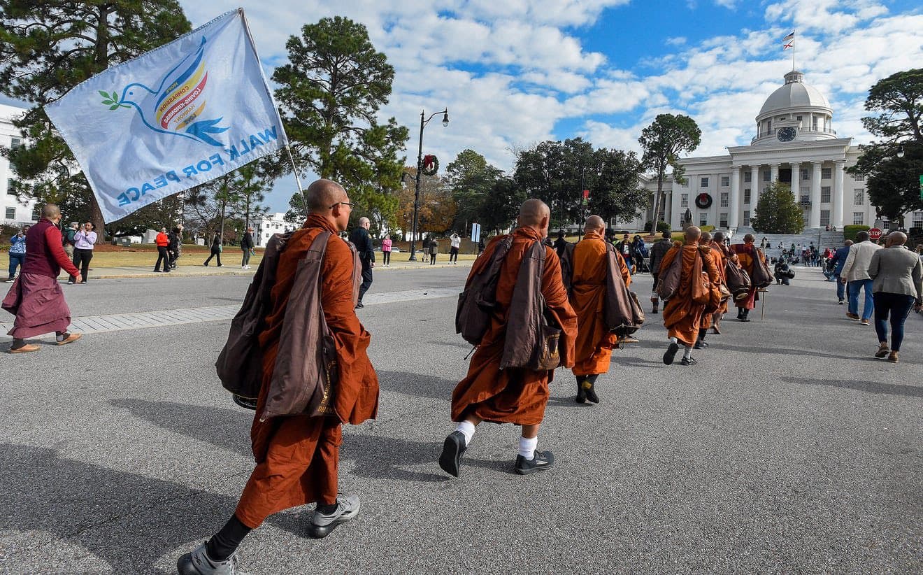 Buddhist monks walk toward the Alabama Capitol.