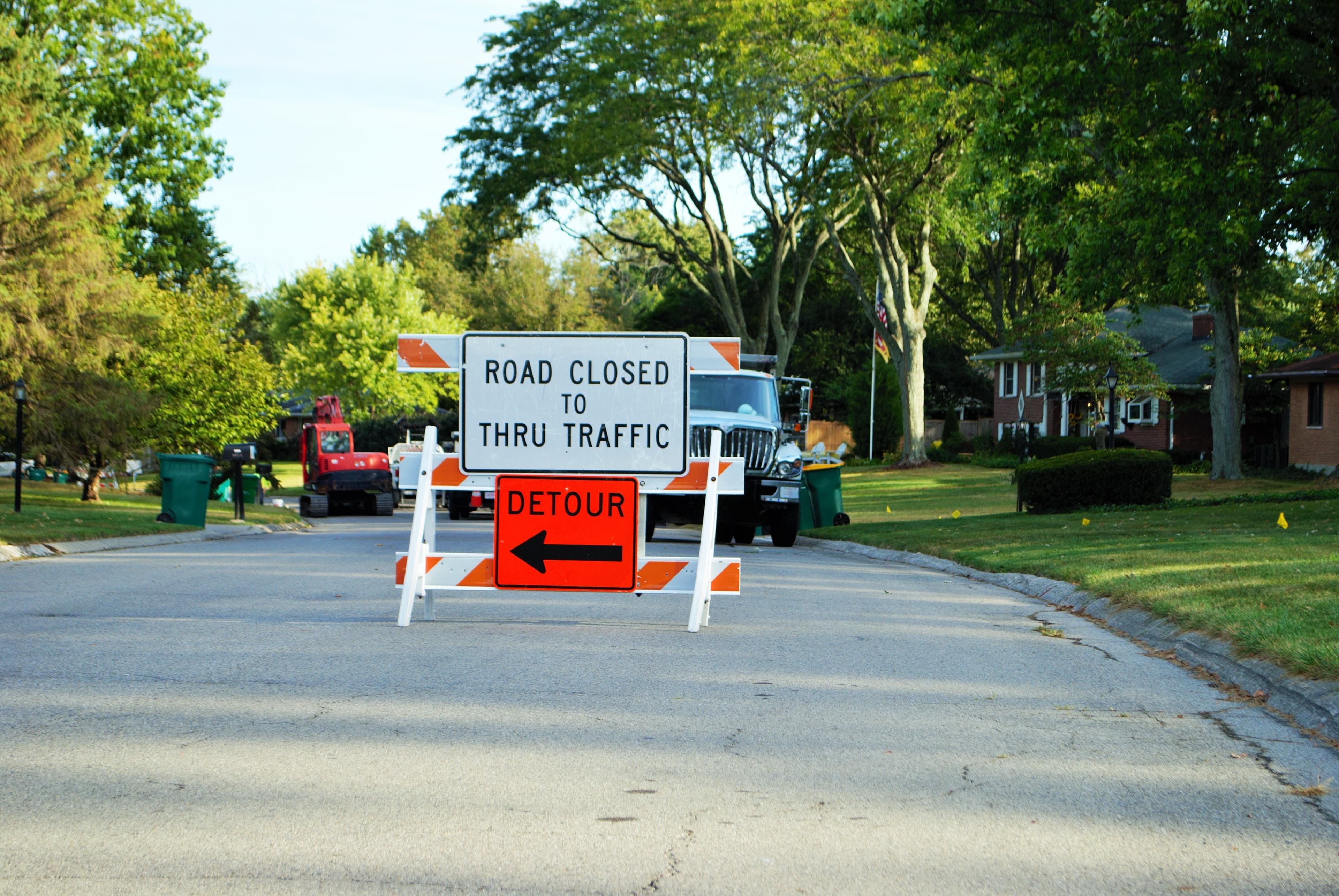 road closed to thru traffic detour construction sign in a residential neighborhood