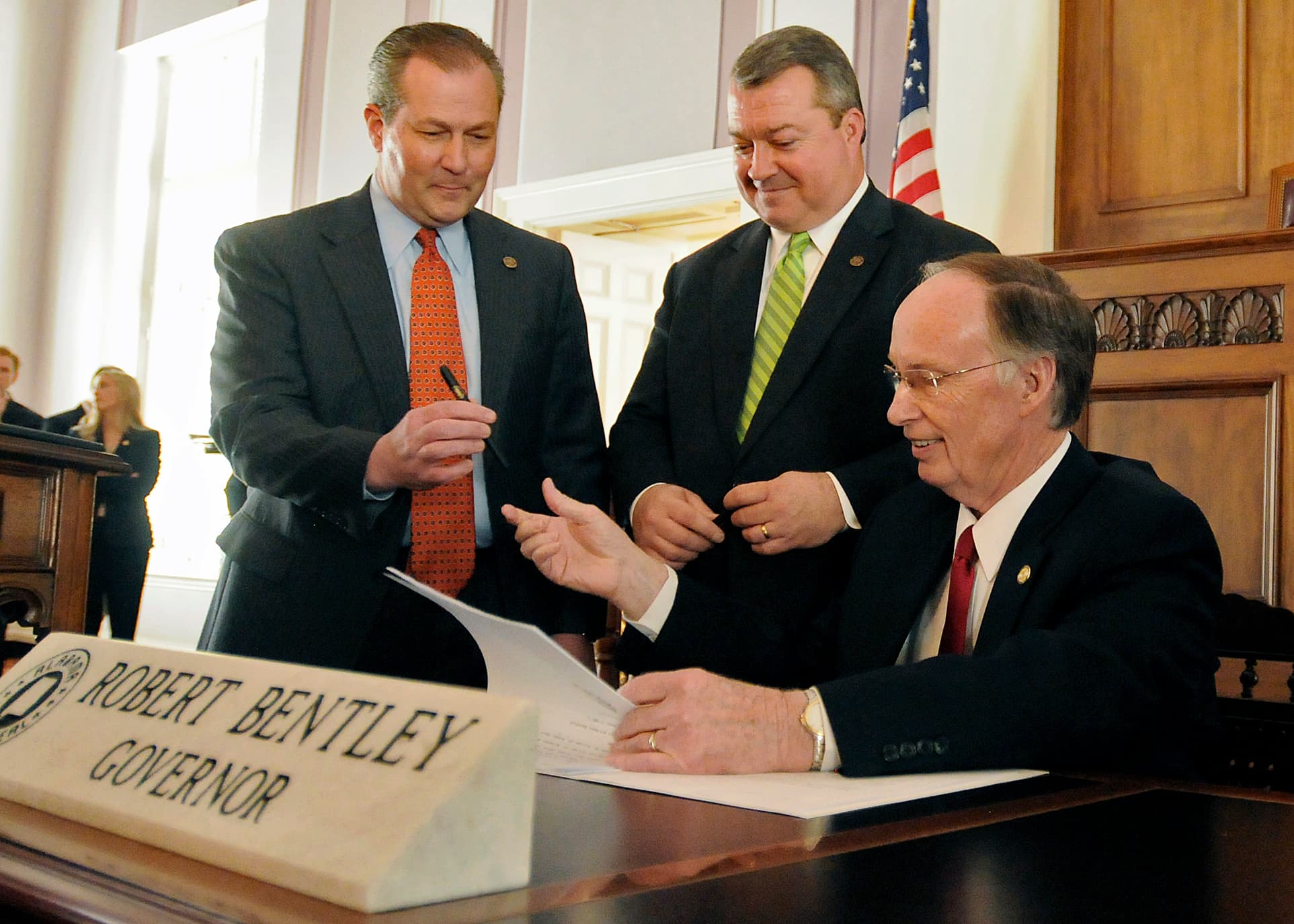 Alabama Gov. Robert Bentley, seated, passes a pen to Alabama Speaker of the House, Rep. Mike Hubbard, R-Auburn, left, as he signs into law the Responsible Budgeting and Spending Act with Rep. Greg Canfield, R-Vestavia Hills, in a ceremony at the Alabama State Capitol in Montgomery, Ala., Friday, March 11, 2011. The bill, sponsored by Canfield, is the first passed in this year's regular legislative session and allows for a "rolling reserve" process to make the Education Trust Fund resistant to proration. (AP Photo)