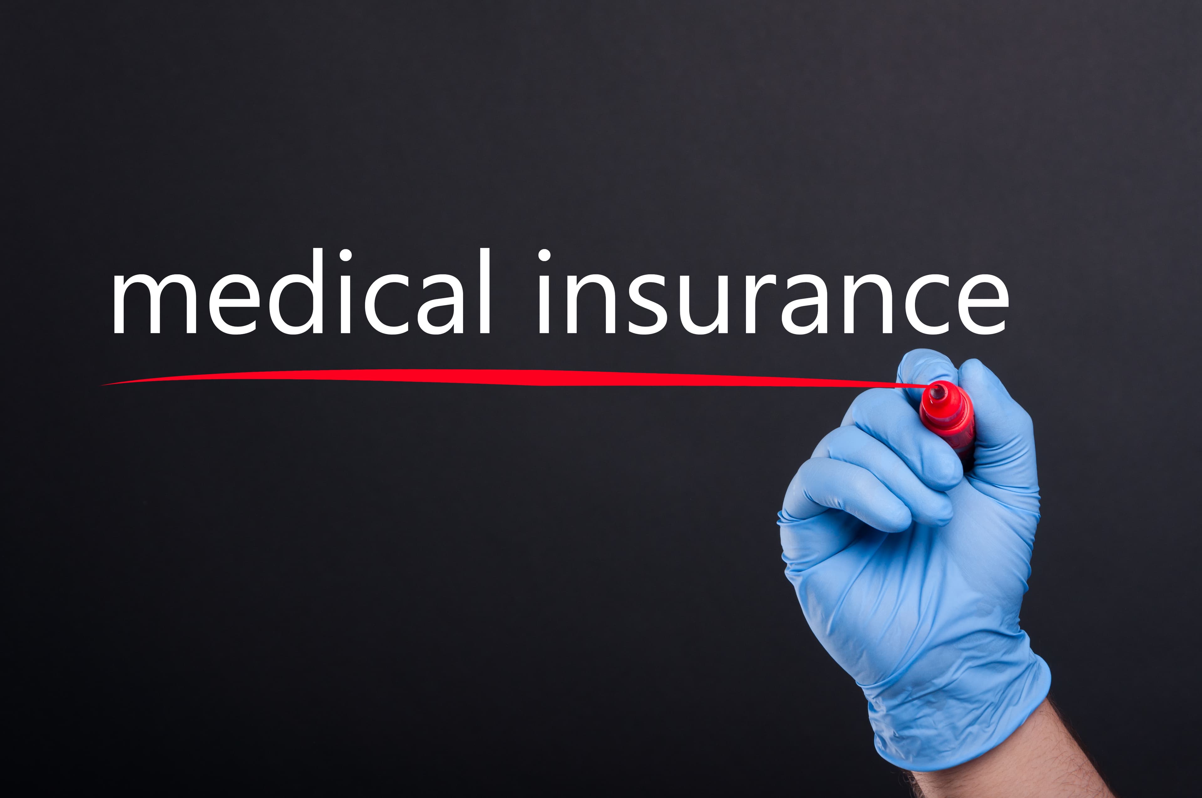 Medical doctor writing medical insurance on blank screen in closeup view isolated on black background