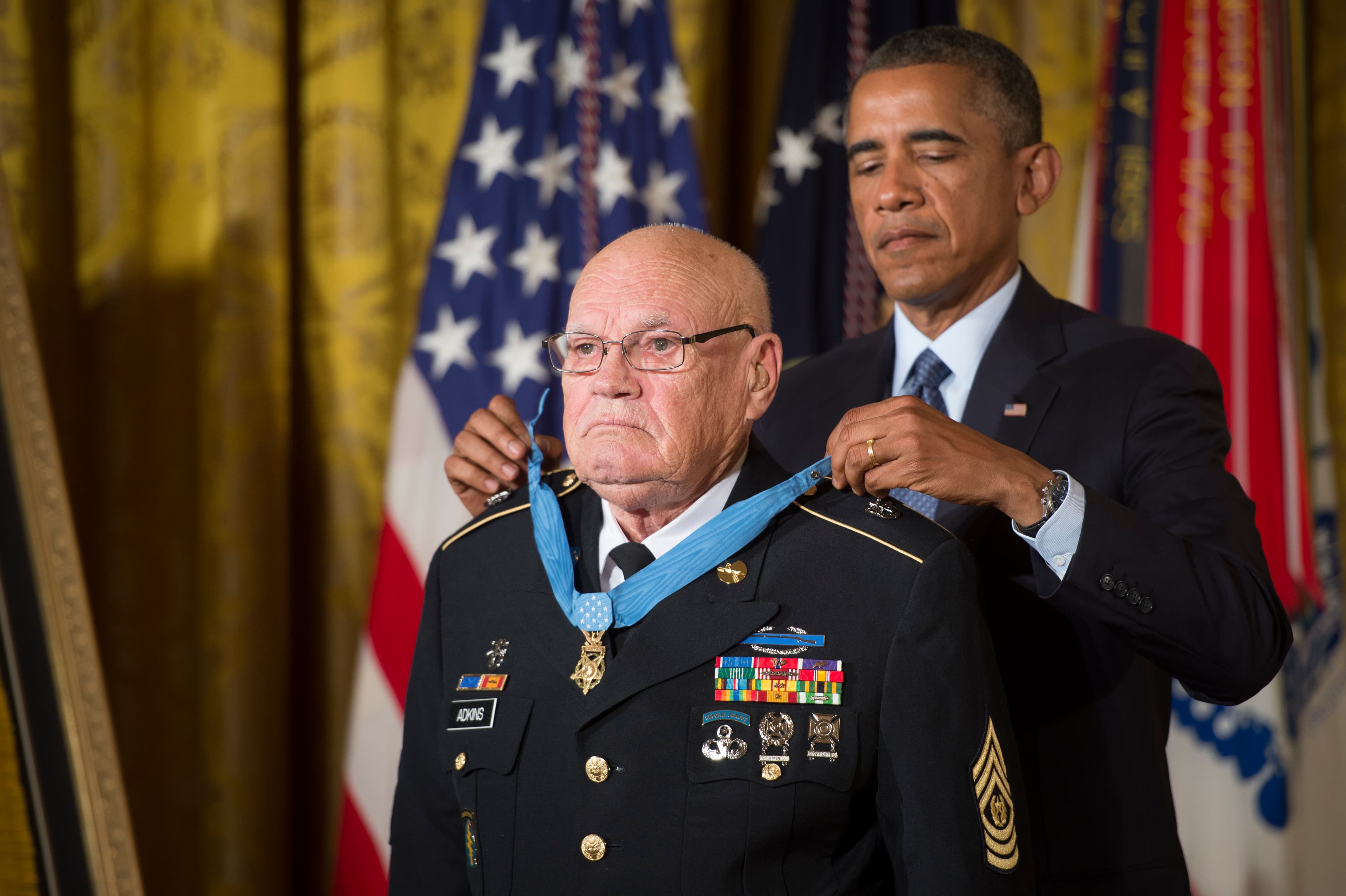 President Barack Obama bestows the Medal of Honor to retired Command Sgt. Maj. Bennie G. Adkins in the East Room of the White House, Sept. 15, 2014. Adkins distinguished himself during 38 hours of close-combat fighting against enemy forces on March 9 to 12, 1966. At that time, then-Sgt. 1st Class Adkins was serving as an Intelligence Sergeant with 5th Special Forces Group, 1st Special Forces at Camp "A Shau", in the Republic of Vietnam. During the 38-hour battle and 48-hours of escape and evasion, Adkins fought with mortars, machine guns, recoilless rifles, small arms, and hand grenades, killing an estimated 135 - 175 of the enemy and sustaining 18 different wounds. (U.S. Army photo by Staff Sgt. Bernardo Fuller/Released)